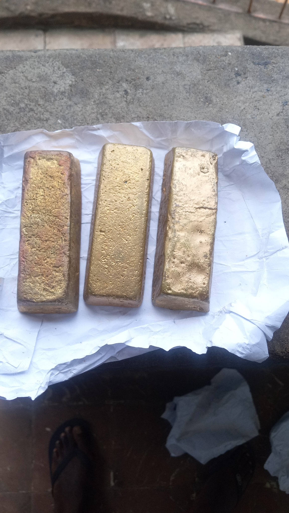 Gold-coloured rectangular bars photographed by the company contact; composition and purity are not verified